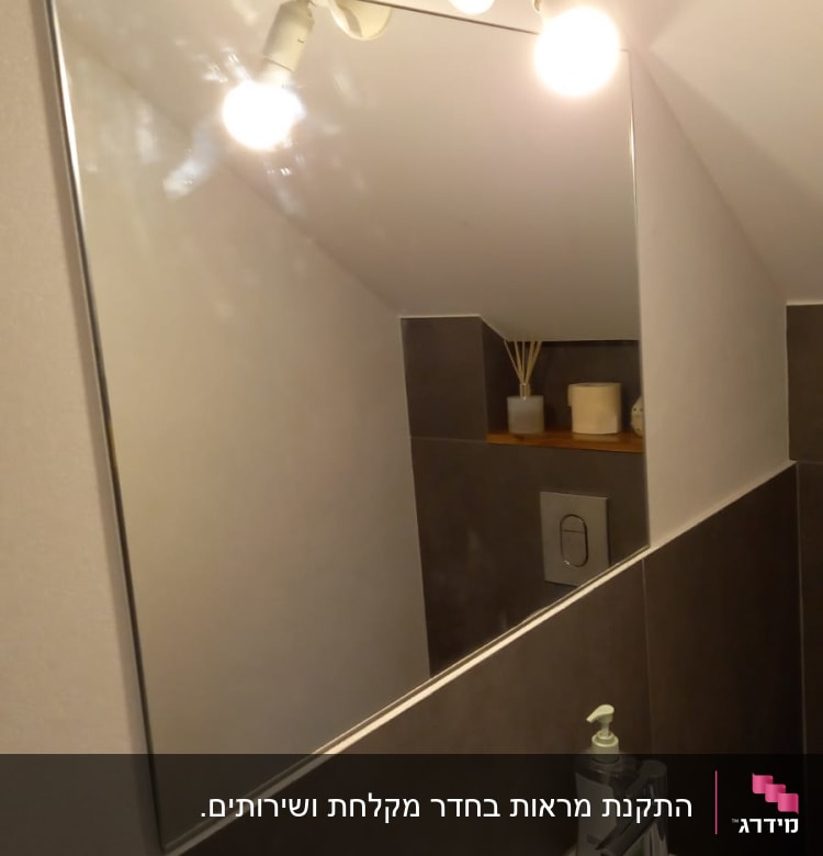 מראה מלבנית תלויה על קיר בחדר אמבטיה